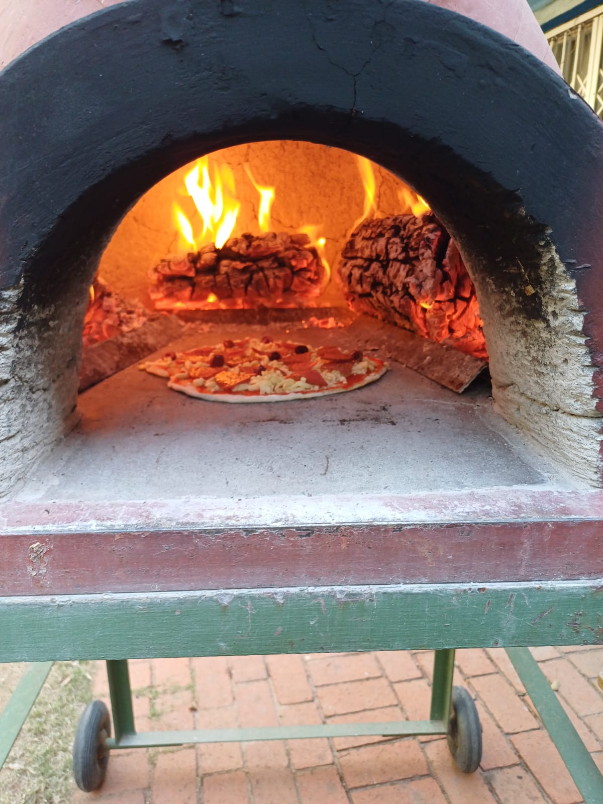 Pizza going into the wood-fired oven
